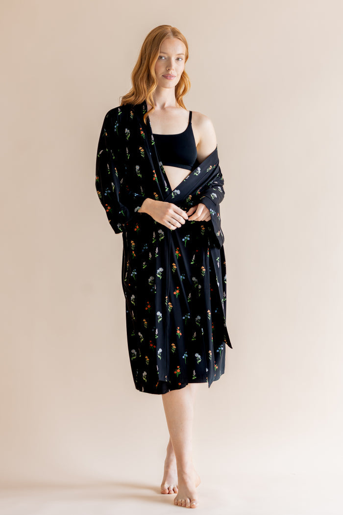 Model wearing Women’s Kimono Robe in Midnight Wildflower print and black bra on a beige background