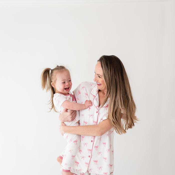 A mom modeling Women’s Short Sleeve Pajama Set in Bow while holding daughter with matching pajamas close up