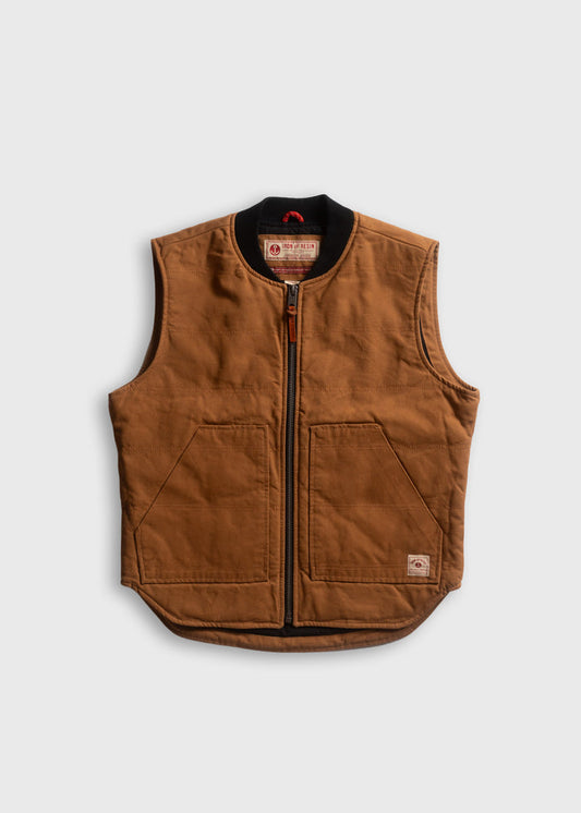 Brown canvas vest with front zipper and two large pockets, featuring a black collar and branded label, on a plain background.