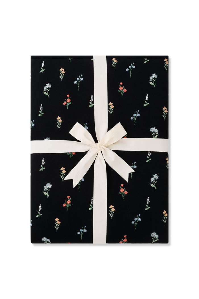 Black Youth Blanket in Wildflower 2.5 print packed with a ribbon on a white background