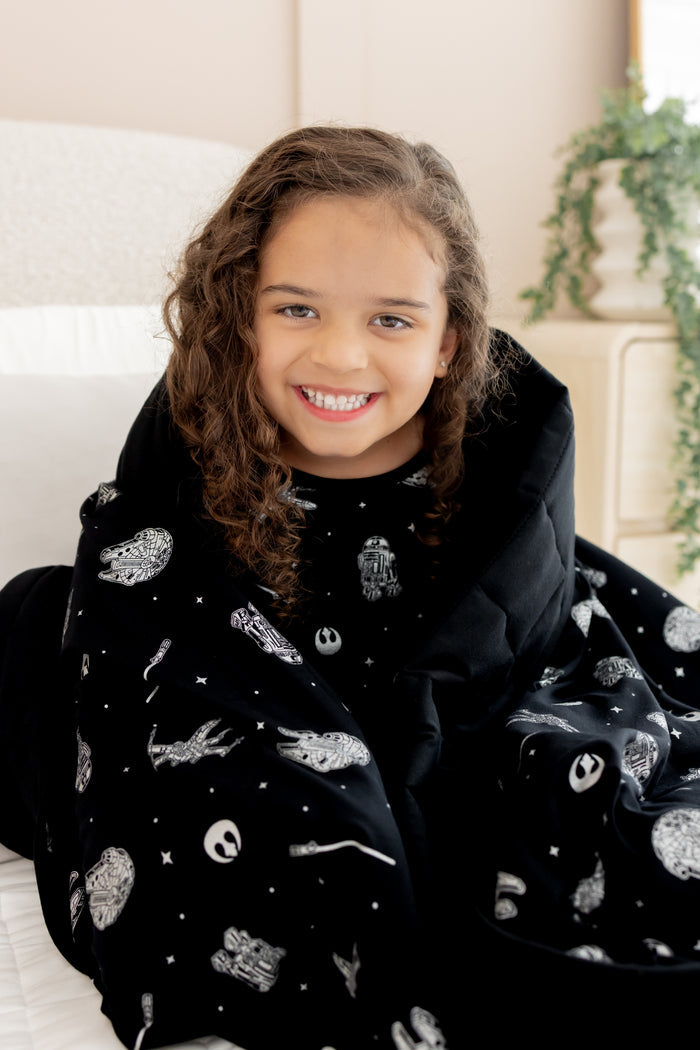 Girl smiling wrapped in Youth Blanket in STAR WARS™ 2.5 print